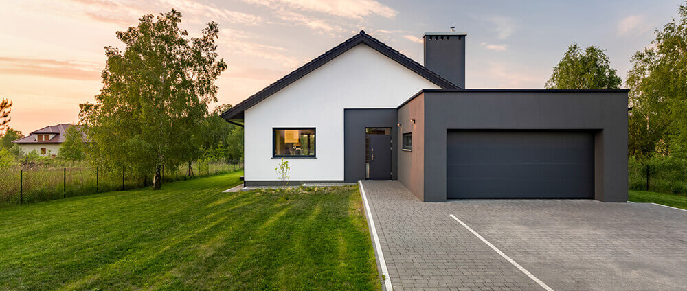 Schwarze moderne Garage am Haus mit schwarzen Zaun
